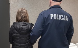 zatrzymana kobieta do usiłowania oszustwa obok umundurowany policjant