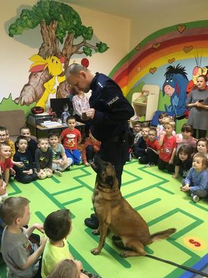 Policyjny przewodnik psa wraz z psem służbowym oraz przedszkolaki biorący udział w profilaktyce