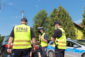 policjant i funkcjonariusze Straży Ochrony Kolei podczas akcji Bezpieczny Przejazd - szlaban na ryzyko
