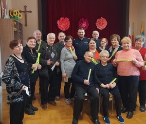 policjant z seniorami, którzy tzymają w rękach elementy odblaskowe