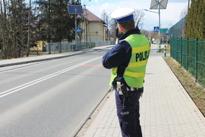 policjant trzymający w ręku radarowy miernik prędkości