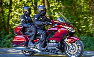 dwoje motocyklistów w trakcie jazdy szosą, w tle las, zdjęcie poglądowe