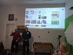 Policjant ruchu drogowego oraz tłumacz języka migowego, na ścianie wyświetlona jest prezentacja