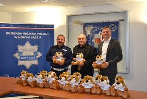 wspólne zdjęcie p.o. naczelnika WRD oraz przedstawicieli fundacji, wszyscy trzymają w dłoniach maskotki