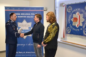 Komendant ściska dłoń panu Piotrowi wręczając list gratulacyjny