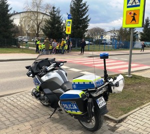na pierwszym planie służbowy motocykl, w tle gromadka przedszkolaków, policjanci i przedstawiciel MORD