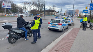 policjanci stojący przy radiwozach w trakcie kontroli kierującego motocyklem na jednej z krakowskich ulic