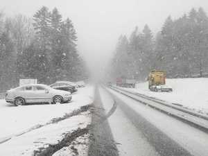 zaśnieżona droga, zimowe warunki, zaśnieżone samochody stoją na poboczu i parkingu