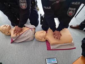 umundurowani policjanci na fantomach wykonują resuscytację krążeniową