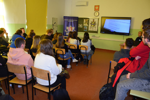 uczniowie siedzący tyłem do zdjęcia, oglądają  film