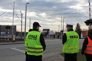 policjant, funckjonariusze straży ochrony kolei, pracownik PKP w pobliżu przejazdu kolejowego