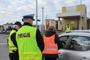 służby wręczające kierowcy ulotkę dotyczącą zasad bezpiecznego przejazdu