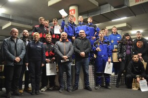 Zdjęcie grupowe - zawodnicy na podium, opiekunowie, działacze, organizatorzy i policjantka ruchu drogowego