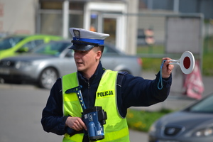 Policjant ruchu drogowego zatrzymujący pojazd do kontroli tarczą