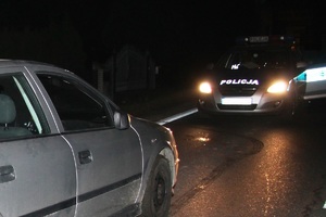nocna Kontrola drogowa radiowóz stoi na ulicy z włączonymi światłami przed nim samochód osobowy
