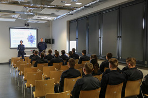 policjanci w sali wykładowej rozmawiają z uczniami klas munudorwych