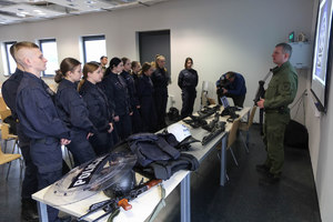 policjant prezentuje uczniom klas mundurowych broń, sprzęt i umundurowanie funkcjonariuszy