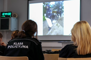 uczniowie klas mundurowych w sali wykładowej oglądają film instruktażowy