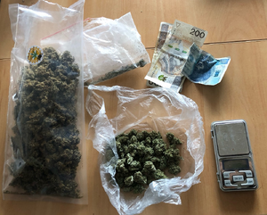 zabezpieczone przez policjantów woreczki z zawartością suszu roślinnego, waga elektroniczna i gotówka