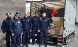 policjanci przed ciężarówką z darami