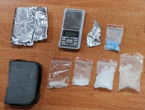 część zabezpieczonych przez policjantów środków odurzających - biały proszek i niebieskie tabletki w woreczkach strunkowych