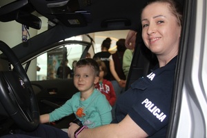 Policjantka i chłopczyk siedzą w policyjnym radiowozie