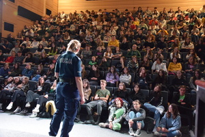 policjantka w sali teatru prowadzi wykład dla młodzieży
