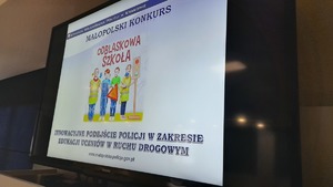 monitor na sali odpraw na którym wyświetla się napis Odblaskowa Szkoła i animacje dzieci