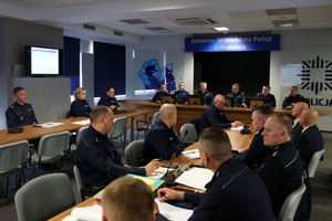 policjanci na sali odpraw siedzący na spotkaniu roboczym w sprawie Odblaskowej szkoły