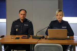 policjant i policjantka siedzący przy stoliku