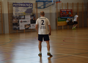 Zawodnicy policyjnej drużyny. Na pierwszym planie zawodnik w koszulce z numerem 2 i napisem POLICJA  oraz POWIAT BOCHEŃŚKI