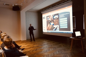 policjant przedstawia seniorom jak bezpiecznie kozystać z urządzeń mobilnych