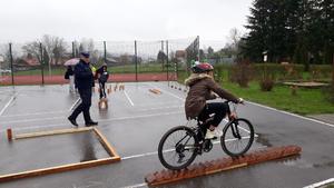 Policjant na torze rowerowym kontroluje prowidłowość przejazdu uczestnika zawodów