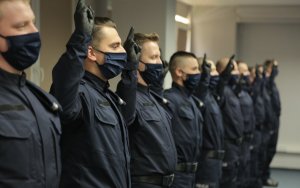 Policjanci w trakcie ślubowania z podniesionymi prawymi dłońmi