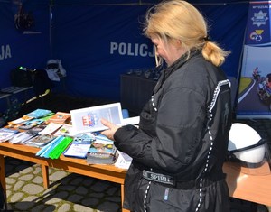 kobieta trzyma w ręce ulotkę z informacjami o rekrutacji do służby w Policji