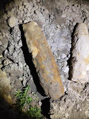 skorodowane pociski artyleryjskie w ziemi - pora nocna , przedmioty oświetlone