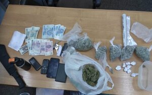 zabezpieczone narkotyki, telefony, maczeta, gaz oraz gotówka leżące na stole