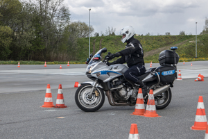 Policjant ruchu drogowego na motocyklu jeździ między pachołkami