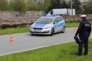 Policjant przygląda się jak radiowóz pokonuje slalomem pachołki