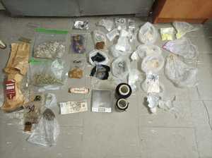 narkotyki w workach foliowych, gotówka, waga elektroniczna, czarna folia oraz papierowe torby ułożone na podłodze
