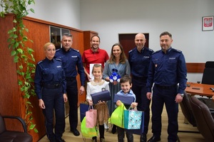 wspólne zdjęcie dzieci ich rodziców z policjantami w gabinecie komendanta