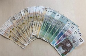 Zabezpieczone pieniądze. Rozłożone w formie wachlarza banknoty o nominale dwieście, sto, pięćdziesiąt, dwadzieścia i dziesięć złotych.