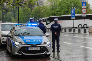 Radiowóz i policjant stojący obok na ul. Grodzkiej