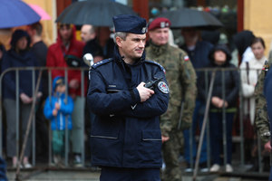 Policjant zabezpieczający plac Studzińskiego rozmawia przez radiostację