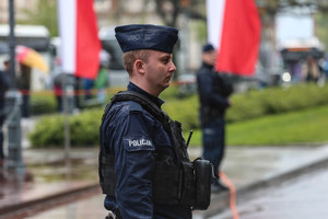 Przemoczony od deszczu policjant na placu Matejki