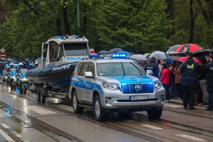 Policyjny pojazd terenowy ciągnący łódź motorową