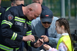 Gruziński policjant wręcza dziewczynce pamiątkową odznakę