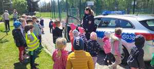 policjantka wraz z przedszkolakami podczas prezentacji radiowozu policyjnego