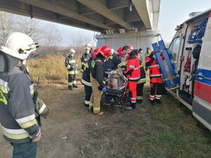 Grupa ratowników przy zaginionym leżącym na noszach owinięty folia termoizolacyjną