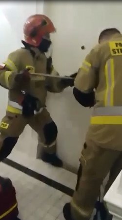 strażacy wyważają drzwi